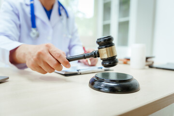 A male doctor sits at a desk, holding a signature pen, discussing medical law. This law safeguards...