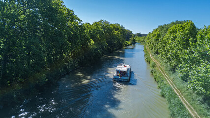 Fototapeta premium Vacation boat in Canal du Midi, family travel cruise by barge penichette, holidays in Southern France