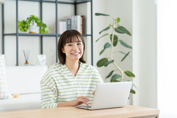 リビングでパソコンを使う若い女性