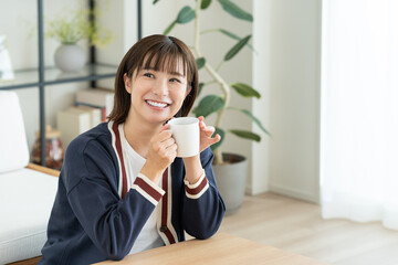 リビングでコーヒーを飲む若い女性