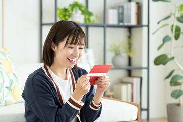 通帳を見る若い女性