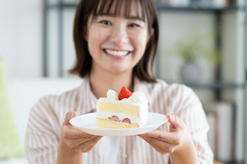 ショートケーキを食べる若い女性