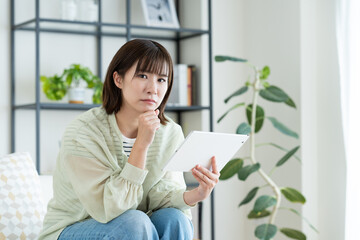 タブレットで悩む若い女性