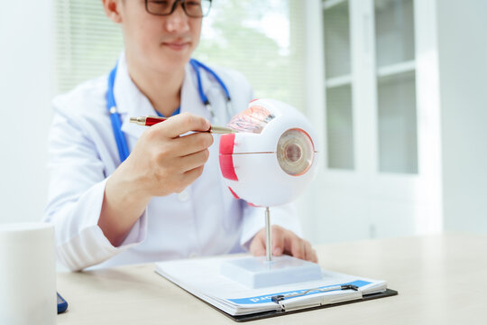 A male doctor wearing glasses sits at a desk in a hospital, explaining eye diseases like glaucoma, cataracts, pterygium, and diabetic retinopathy. Early detection helps prevent vision loss