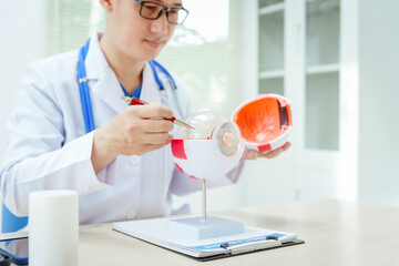 A male doctor wearing glasses sits at a desk in a hospital, explaining eye diseases like glaucoma, cataracts, pterygium, and diabetic retinopathy. Early detection helps prevent vision loss