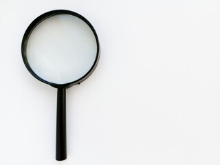 A black magnifying glass on a white background. An empty space for the text. Research work. Scientific research. Background.