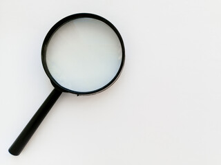 A black magnifying glass on a white background. An empty space for the text. Research work. Scientific research. Background.