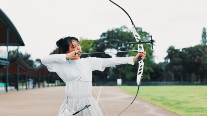 Aim, athlete and woman with bow, field and serious for challenge, training and equipment for sport....