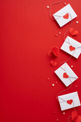 Heartfelt Valentine's day vertical theme with envelopes and paper hearts on a vibrant red background, capturing the essence of love and affection