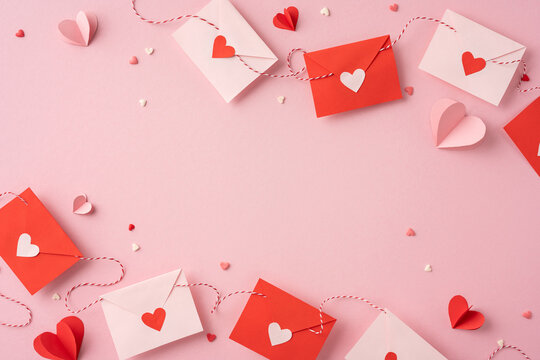 A collection of red and pink envelopes on a pastel background, adorned with heart-shaped decorations, conveying a feeling of love and romance for Valentine's Day