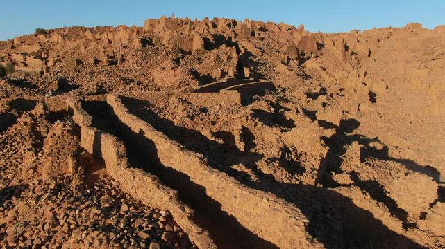 Ruins of ancient and historic city of Ouadane, Mauritania in Africa. Aerial forward ascending