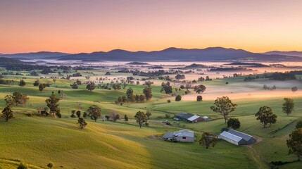 A breathtaking sunrise over rolling hills and farmland, showcasing lush greenery, scattered trees, and mist rising from the valleys.