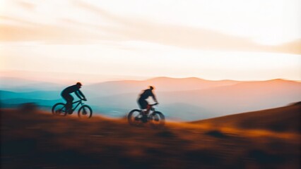Obraz premium Biking Through Mountain Range Blur – Cross-country bikers with a blurred mountain landscape at sunset. 