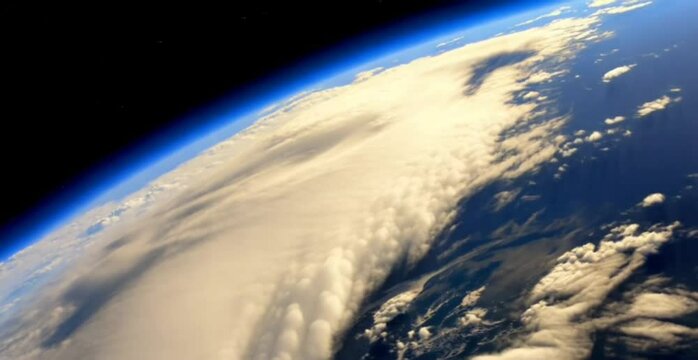 A breathtaking view of Earth from space, showcasing its curved horizon, swirling clouds, and deep blue atmosphere, highlighting the planet's beauty and vastness.