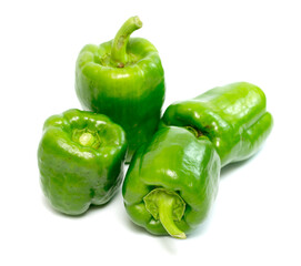 Four green peppers are sitting on a white background