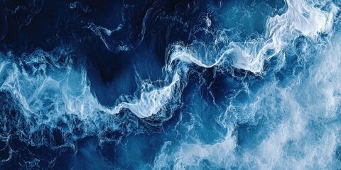 Fototapeta premium The image is of a large wave in the ocean, with the water appearing to be blue and white. The wave is crashing against the shore, creating a sense of power and movement. Scene is one of awe and wonder