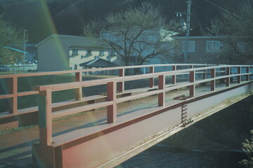 キレイに照らされた川にかかる古い赤い橋