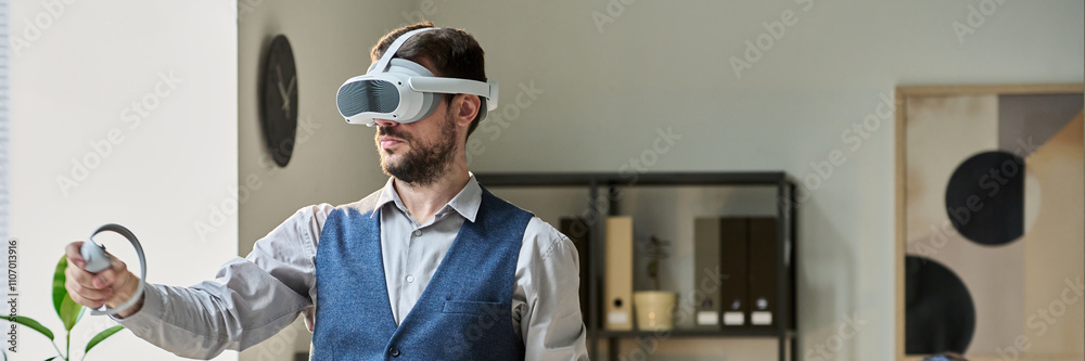 Poster Header of young modern businessman with VR headset using controllers while making presentation of new project against colleague