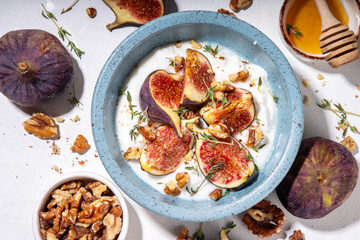 Creamy rich and tasty yogurt dessert with autumn figs, granola and nuts