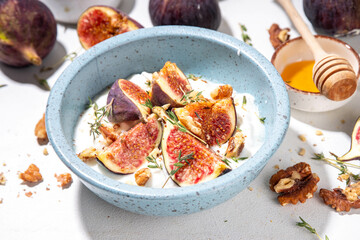Creamy rich and tasty yogurt dessert with autumn figs, granola and nuts