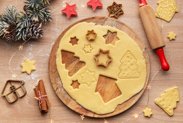 Preparing christmas cookies with dough, cutters, and festive decorations