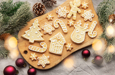Christmas cookies decorated with icing lying on wooden board