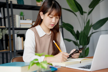 Asian girl student doing exam hand holding pencil writing answer in university classroom education high school or university student taking notes while preparing for exam