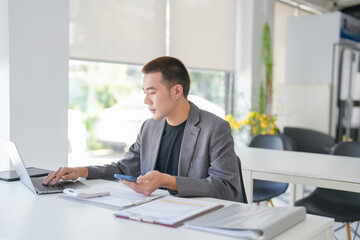Young Business man holding Smartphone working mobile devices. cell telephone technology e-commerce smartphone for business work