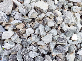 Various sizes of natural stones lay scattered, offering a rugged texture suitable for decorative or...