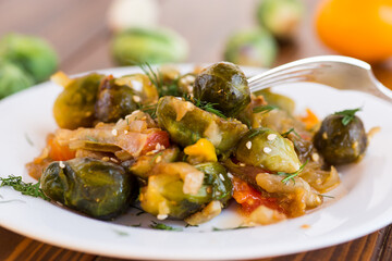 Brussel sprouts cooked with vegetables, on a wooden table