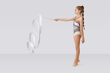 Young beautiful sportive girl, female rhythmic gymnast exercise with white ribbon. Sport, beauty, competition, flexibility, active lifestyle.