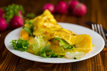 egg roll with sweet pepper and salad, on a wooden table