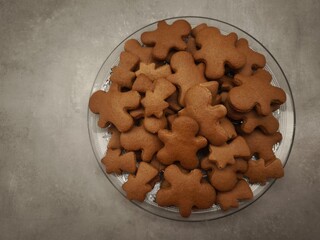 Gingerbread men and comets shaped cookies arranged on a glass plate, capturing the essence of christmas baking and holiday cheer