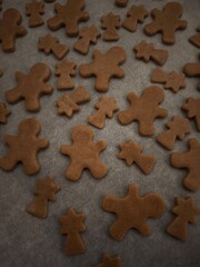 Gingerbread men and comets cookies baking on a tray and paper, ready for the holiday season christmas