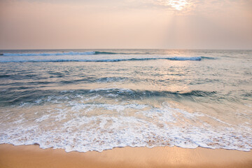 The ocean is calm and the sky is a beautiful soft pink color