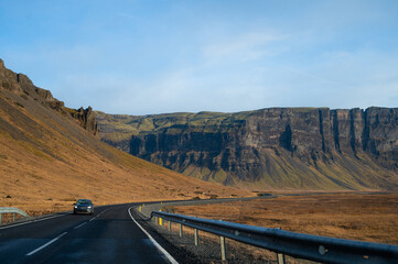 Car on asphalt road in Iceland. Touristic travel route. Beautiful landscape. Cloudy sky. Icelandic...