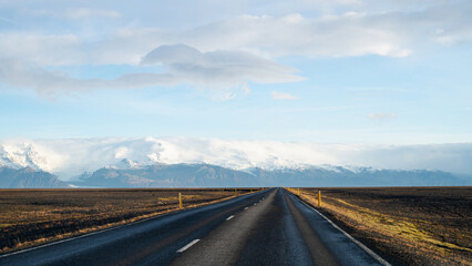 Empty asphalt road in Iceland. Touristic travel route. Beautiful landscape. Cloudy sky. Glacier.
