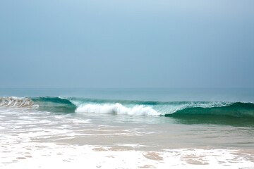Beautiful blue waves with foam near the shore of the Ocean