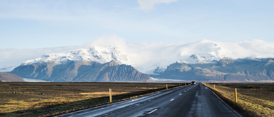 Empty asphalt road in Iceland. Touristic travel route. Beautiful landscape. Cloudy sky. Glacier.