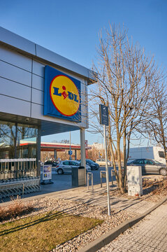 Vertical shot of the facade of Lidl supermarket with the company logo next to the parking lot