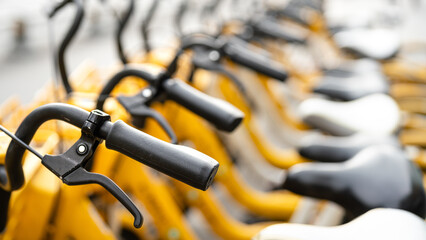 Group of rental bicycles that parking in the city, transportation service vehicle for eco-friendly. Close-up with selective focus at handlebar part.