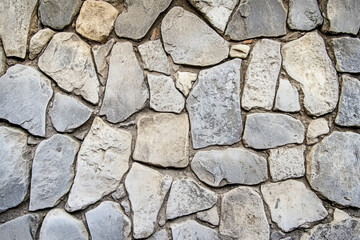 Obraz premium Textured cobblestone street, aged gray stones with visible weathering and irregular grooves, historic and tactile