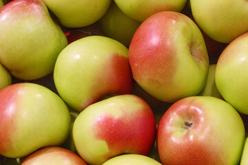
red-green apples stacked in a pile at the market