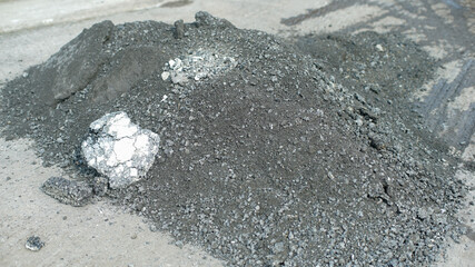 Crushed asphalt debris piled up on the road