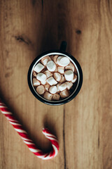 Top view of delicious Christmas cocoa with marshmallow on wooden table.
