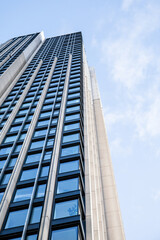 Building with windows, view from below, clouds in the sky