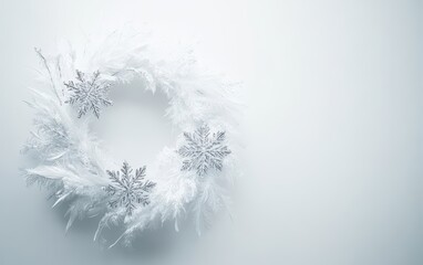 Obraz premium A winter-themed wreath made of white feathers and sparkling snowflake ornaments on a simple white backdrop