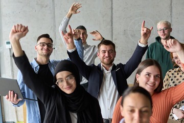 A diverse team of business professionals ecstatically celebrating their success in a modern office, expressing triumph and unity after achieving their goals