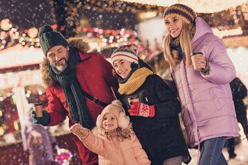 Photo of friendly beautiful family enjoy hot chocolate tea spend festive weekend garland bazaar outdoors