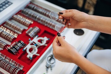 Bunch of objects. Ophthalmologist is picking different lenses that are in the kit